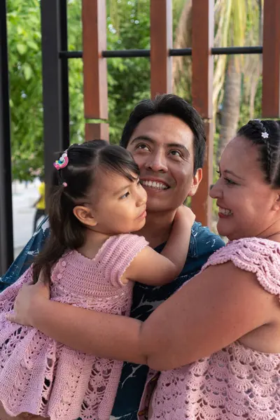 Mutlu İspanyol ailesi kucaklaşıp gülümsüyor.