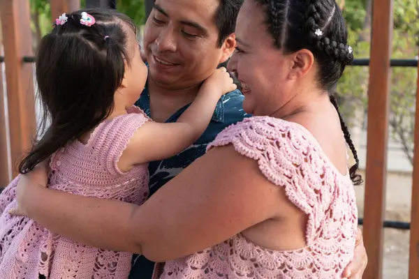 Mutlu İspanyol anne babalar küçük kızlarına sarılıyor, gülümsüyor ve birlikte vakit geçiriyorlar.