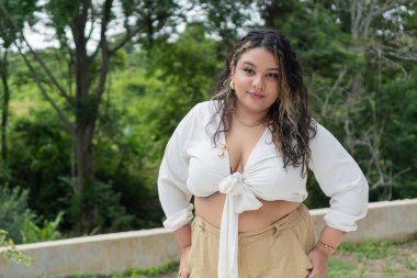 Kıvrımlı manken, açık havada güven içinde poz veriyor, büyük boy güzellik ve vücut pozitifliği sergiliyor.