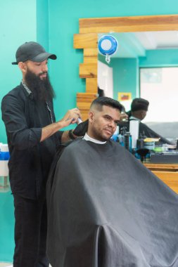Kuaför kuaför kuafördeki müşteriye saç makası kullanıyor.