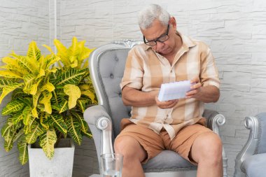 Bir ilaç organizatöründe ilaç düzenleyen yaşlı bir adam, yaşlılar için ev sağlığı ve ilaç yönetimi gösterisi yapıyor