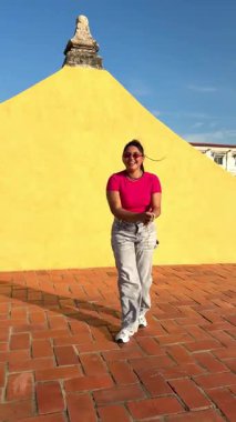 Kartagena de lndias, Kolombiya 'da bir çatıda turist dansları yapıyor, arkasında sarı bir duvar var.