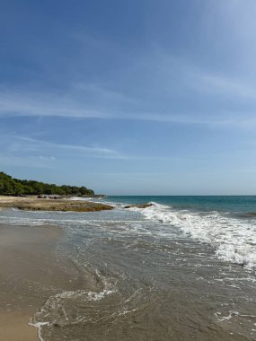 El değmemiş bir plajın kıyısına vuran hafif dalgalar rahatlamak ve kaçmak için mükemmel sakin bir sahne yaratır.