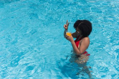 Turistler yaz tatilinde yüzme havuzunda meyve suyu içip tabelayı hazırlıyorlar.