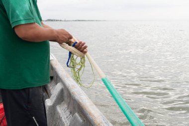Balık tutan balıkçı, okyanusta balık tutmaya hazırlanıyor.