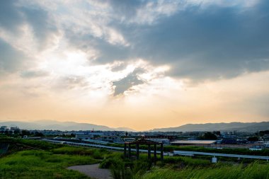 Öğleden sonra (Ikeda, Osaka, Japonya) bulutlu bir günde dağlarla çevrili bir kasaba manzarası)
