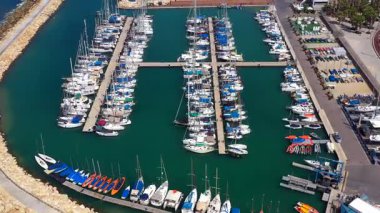 Küçük tekneler ve yatlar büyük bir marinada demirli, yukarıdan aşağıya hava manzaralı..