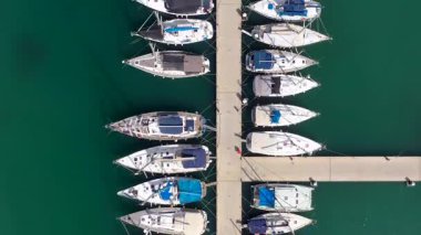 Küçük tekneler ve yatlar büyük bir marinada demirli, yukarıdan aşağıya hava manzaralı..