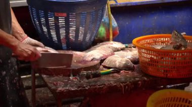 Bangkok, Khlong Toei 'de balık temizleyen Islak Market işçisi.