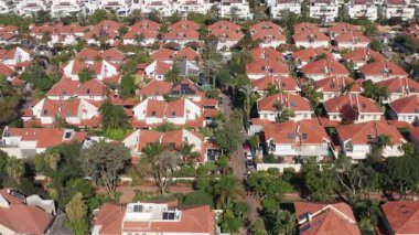 Kırmızı çatıları ve yeşil ağaçları olan klasik Suburban evleri.