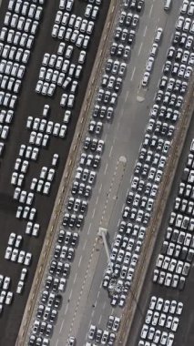 Gıcır gıcır yeni arabalar büyük bir otoparka park edilmiş, hava manzaralı.