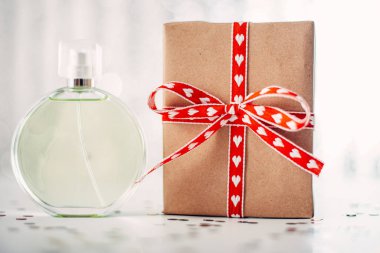 Kırmızı hediye kutusu olan cam kokulu parfüm şişesi.