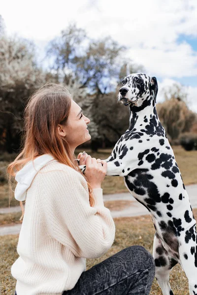 girl with a dalmatian dog in nature.