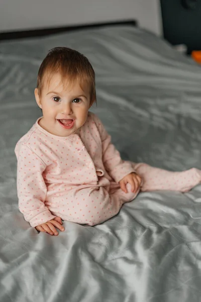 Kislány Első Fogakkal Rózsaszín Pizsamában Ágyon — Stock Fotó