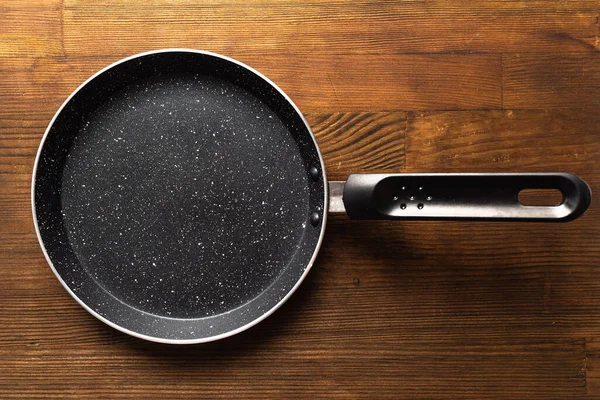 Ahşap arka planda krep için boş tava.