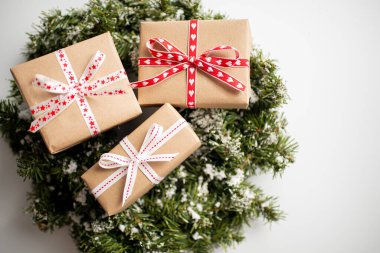 Beyaz arka planda hediye kutusu olan Noel çelengi