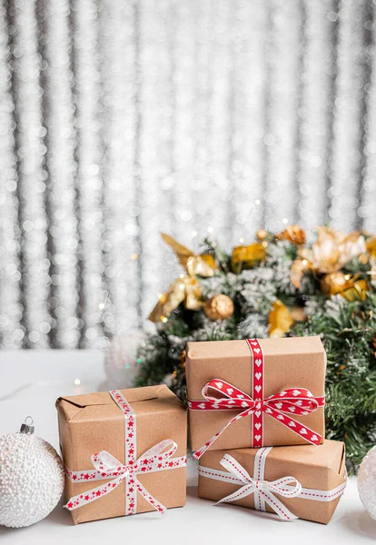 装饰圣诞树和木制桌子上的礼品盒 挡住朦胧的灯光 免版税图库图片