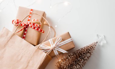 İçinde hediye kutusu ve Noel süsü olan bir alışveriş çantası. Noel hediyesi alıyorum..