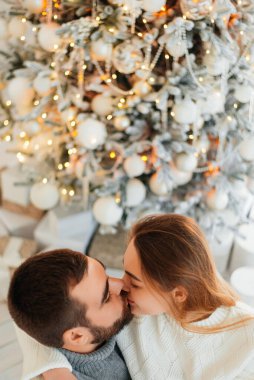 Genç bir adam ve genç bir kız birbirlerini seviyorlar. Küçük bir Noel ağacının yanında samimi kazaklarla sarılıp öpüşüyorlar..