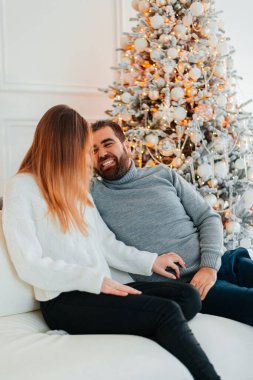 Çekici bir çift Noel ağacının yanında Noel hediyelerini açıyor..