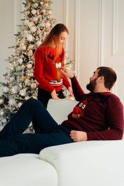 Birbirimize, Noel, yeni yıl ağacı yakınındaki kanepede oturan hafifçe gülümseyerek aşık bir çift.