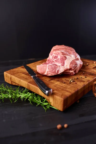 Raw meat. Raw beef steak on a cutting board with rosemary and spices