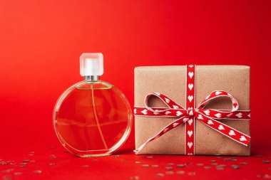Perfume on red background. Gift on valentines day.