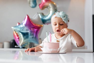 Bir doğum günü pastası ile üç yaşında bir kız.