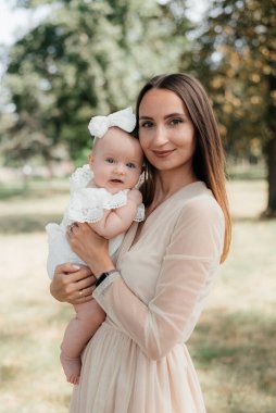 Genç ve güzel anne çocuğuyla dışarıda oynuyor.