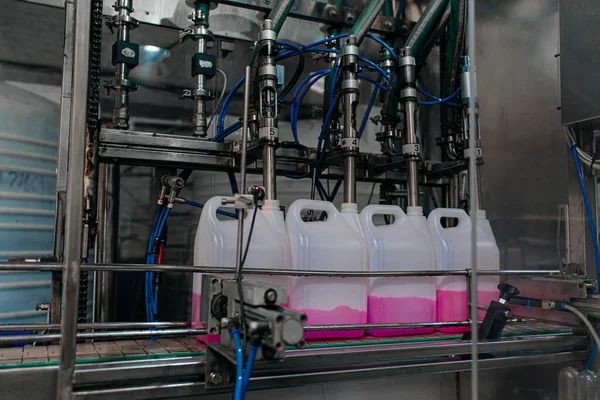 Automatic filling machine pours into plastic PET bottles at modern beverage plant