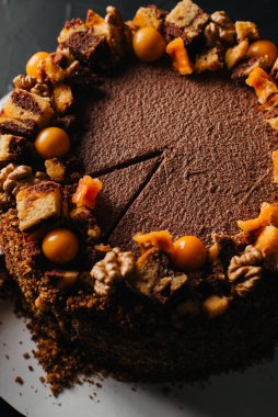 Bıçağın yanındaki masaya konmuş meyve suyu bardağının üst görüntüsü ve beyaz tabakta dilimlenmiş çikolatalı pasta..