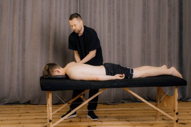 Profesyonel doktor osteopat, manuel terapi kliniğindeki rehabilitasyon kliniğinde egzersiz yaparken ellerini arkaya uzatıyordu. İş sırasında kiropraktör..