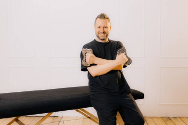 Masaj odasındaki terapist kameranın önünde poz veriyor. Gülümsüyor ve güzellik ve kaplıca kavramının sonunda el ele tutuşuyor...