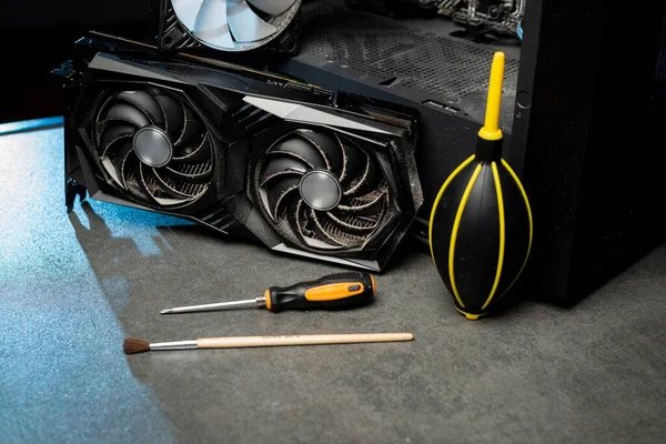 Cleaning a graphic card fan with a brush. Cleaning PC concept.