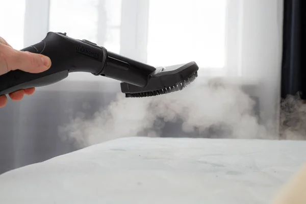 cleaning mattress with professional equipment in bedroom, closeup.