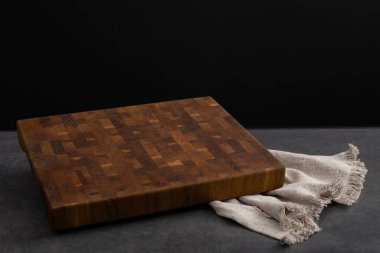 Siyah taş bir masada kesme tahtası. Mutfak geçmişi. Boş tahta kesme tahtası, ürün görüntüleme alanı