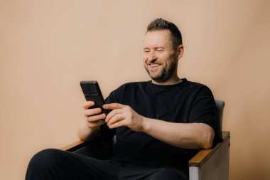 Bej arka planda duran gülümseyen olgun bir adamın portresi