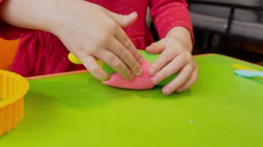 Çocuk elleri renkli kille oynuyor. Ev yapımı plastik. Plastiksin. Hamur oyna. Kil kalıbı yapan kız. Ev yapımı kil
