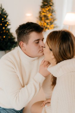 İnsanlar ve tatil konsepti. Arka plandaki çirkin süveter partisinde mutlu çiftin portresi..