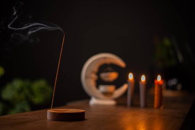 Tütsü çubuğu yanar ve küçük mumlarla çevrili aromatik dumanlar üretir..