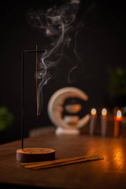 Tütsü çubuğu yanar ve küçük mumlarla çevrili aromatik dumanlar üretir..