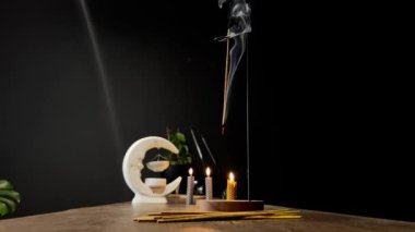 Tütsü çubuğu yanar ve küçük mumlarla çevrili aromatik dumanlar üretir..