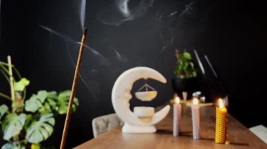 Tütsü çubuğu yanar ve küçük mumlarla çevrili aromatik dumanlar üretir..