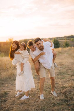 Mutlu bir aile babası, anne ve iki çocuk dışarıda oynuyor, izin günlerinde eğleniyorlar.