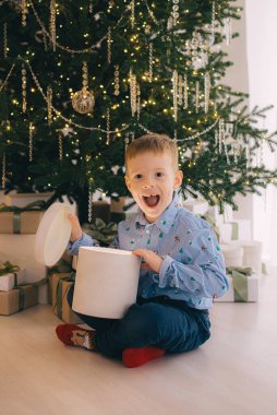 Mutlu noeller. Mutlu çocuklar ve sihirli hediyeleri Noel ağacının yanında..