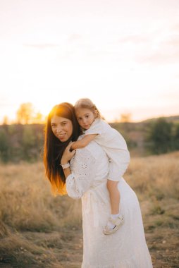 Sevimli genç kızı bir domuz sırtına binmek annesi ile