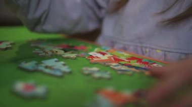 Evde yapboz oynayan pijamalı küçük bir kız. Çocuklar için evde kal.