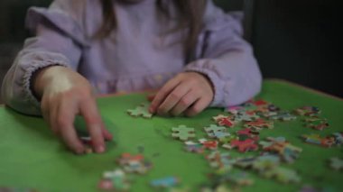 Evde oturup yapboz yaparken eğlenen bir kız..