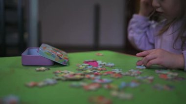 Evde oturup yapboz yaparken eğlenen bir kız..