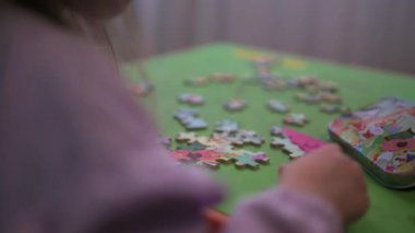 Evde oturup yapboz yaparken eğlenen bir kız..